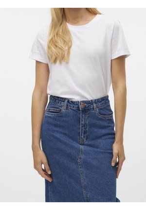 Kvinde iført en ensfarvet hvid t-shirt med korte ærmer, der er stoppet ind i et højtaljet blåt denimskørt med knapper foran og lommer.