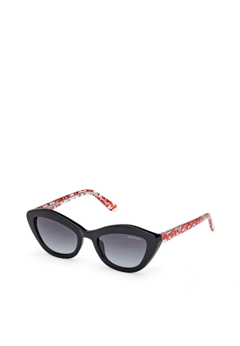 Gafas de sol estilo ojo de gato con montura negra y lentes gris degradado. Las patillas presentan un patrón abstracto en rojo y transparente para un detalle adicional.