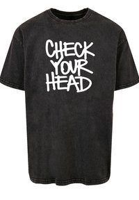 Black cotton t-shirt with short sleeves and a crew neckline, featuring white graffiti-style text "CHECK YOUR HEAD" on the front.