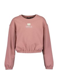 Růžový zkrácený svetr vyrobený z měkké tkaniny. Má dlouhé rukávy, elastický lem a stříbrný nápis "SMILE" srdíčko nad ním.