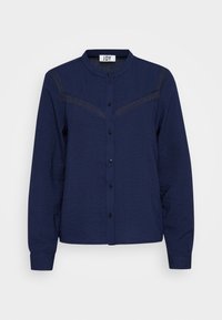 Camicia a maniche lunghe blu navy con colletto tondo, chiusura con bottoni, tessuto testurizzato e pannelli trasparenti sulle spalle.