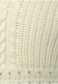 Cream-colored knitted fabric featuring a ribbed pattern with cable designs. Texture appears soft and thick, with openwork accents near the bottom.