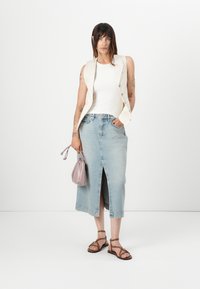Beige uten ermer blazer, hvit ribbet tank topp, lys blå denim skjørt med frontslipp, brune sandaletter med stropper, og lilac håndveske.