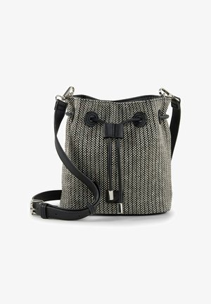 Czarno-biała pleciona torba typu bucket z regulowanym czarnym skórzanym paskiem oraz zamknięciem na sznurek zakończonym metalowymi końcówkami.