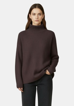 Maglione a collo alto marrone scuro a coste con maniche lunghe, vestibilità comoda e collo alto. Indossato sopra jeans neri, con un design semplice.
