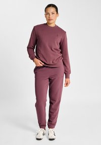 Mauve sweatshirt met een ronde hals en een subtiel logo, gecombineerd met bijpassende joggers met elastische boorden en zijzakken.