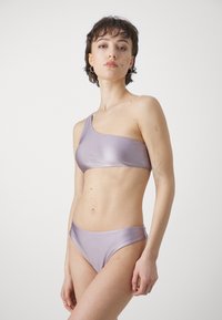 Lilla en-falds bikini topp med en glatt tekstur og matchende underdeler. Har minimal design og subtil merkevare.