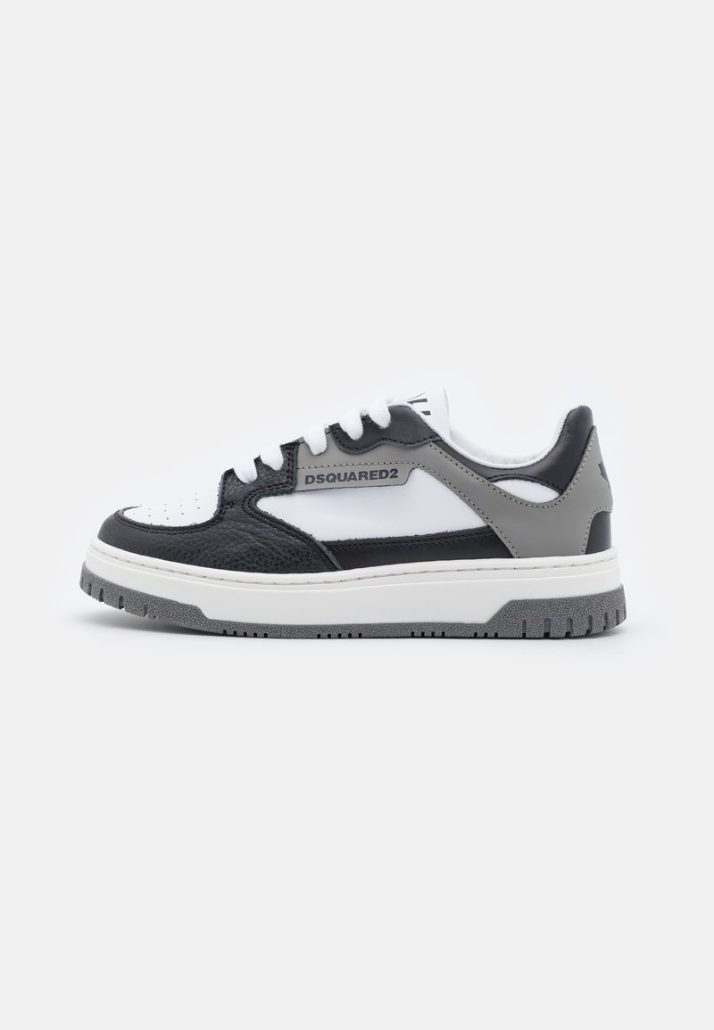 Sneaker bianco e nero con pelle testurizzata, accenti lisci e suola in gomma grigia. Presenta un logo sul lato e un design con lacci.