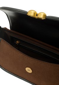 Svart läderhandväska med ett brunt manchesterfoder, som har ett detaljer i guld, en dragkedjeficka och en magnetisk tryckknappstängning.