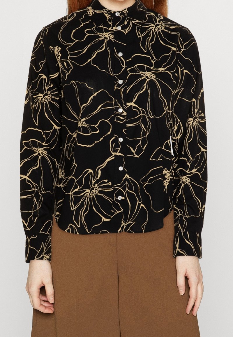 Camicia nera con bottoni, motivo floreale beige, maniche lunghe, colletto a punta e chiusura con bottoni frontale. Tessuto leggero.