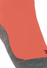 Calcetín coral y gris con un diseño sin costuras, que presenta un puño texturizado y un logo impreso en rojo en el lateral.