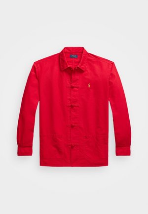 Czerwona kurtka z długim rękawem z tradycyjnym chińskim zapięciem na guziki w stylu żabki, dwie przednie kieszenie, kołnierz i małe żółte logo Polo Ralph Lauren na piersi.