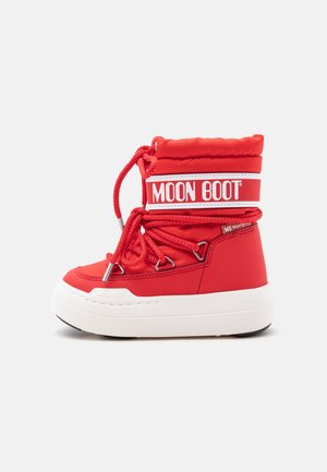 Bota roja Moon con suela blanca gruesa, tobillo acolchado alto y cordones rojos enrollados alrededor de ojales metálicos, vista desde un lado sobre fondo blanco.