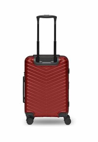 Valise rigide rouge avec un motif en chevrons, poignée rétractable noire et quatre roues à roulement fluide pour une maniabilité facile.