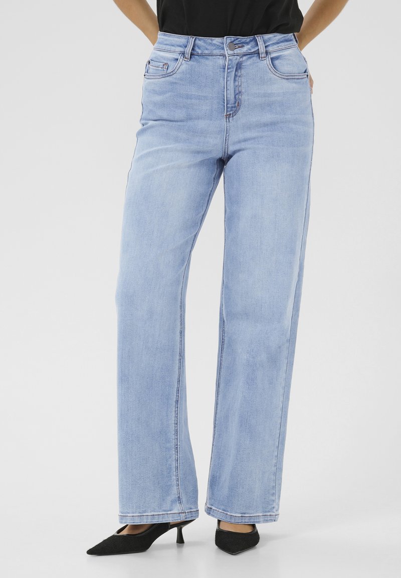 Ljusblå högmidjade vida jeans i denim, med klassisk femfickdesign och diskreta sömnadsdetaljer, i kombination med svarta skor.