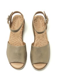 Sandalias de cuero en beige metálico con sentido abierto, tira en el tobillo y plantillas texturizadas con un patrón de hojas. Detalle de suela plana y trenzada.