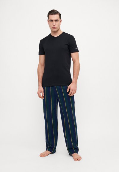Schwarzes Baumwoll-T-Shirt kombiniert mit blauen gestreiften Pyjamahosen, die grüne und gelbe Linien aufweisen, lockere Passform und gerades Bein-Design.