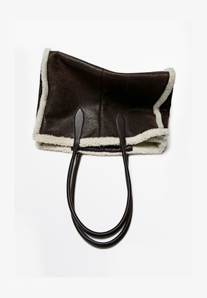 Brązowa torba typu tote ze skóry, z miękkim białym kożuchem i dwoma długimi brązowymi skórzanymi uchwytami, cechująca się przestronnym, otwartym designem.