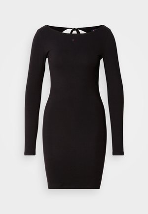 Crna uska haljina dugih rukava s okruglim izrezom i detaljem za vezanje na leđima. Glatka tkanina s jednostavnim, elegantnim dizajnom.