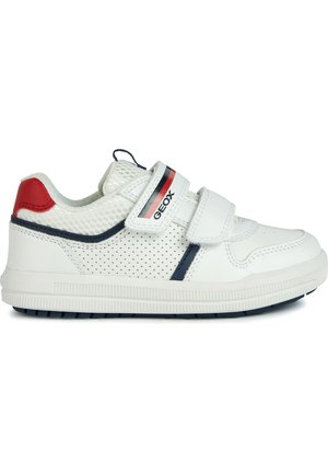 Sneaker bianco con design perforato, linguetta in mesh imbottita e doppie fasce in Velcro. Presenta dettagli rossi e blu navy, suola in gomma per una buona aderenza.