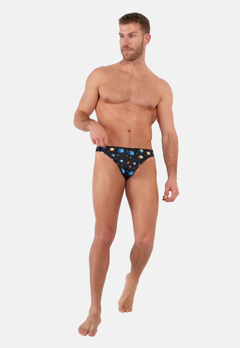 Black swim briefs feature a colorful planetary pattern against a dark background, made from stretch fabric for comfort and fit.