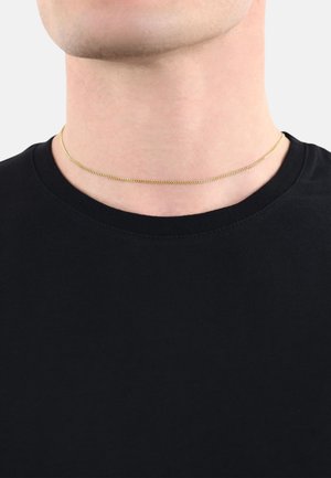 Goldfarbener Metall-Choker-Halsreifen mit einem glatten, flachen Design und feinen Kettengliedern, eng am Hals über einem schwarzen Shirt getragen.