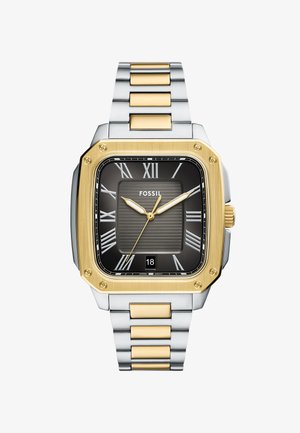 Montre Fossil carrée avec un cadran noir, des accents dorés et des chiffres romains pour les heures. Bracelet en acier inoxydable avec des maillons dorés et argentés. Affichage de la date à 6 heures.