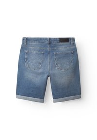 Šviesiai mėlyni džinsiniai šortai su suvyniota apačia. Juosmens juostoje yra juodas ženkliukas, o gale – dvi kišenės su siuvinėta dekoracija.