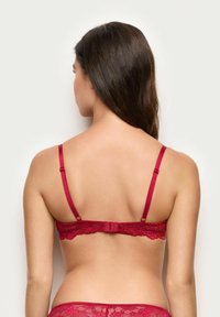 Rød blonde-BH med justerbare satin-stropper, prydet med blomster mønstre og en hægte-lukning, der fremhæver den sarte tekstur og design.