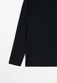 Schwarzes langärmliges Polohemd mit Knopfkraagen, auf einem weißen Hintergrund gezeigt, auf Torso und Arm zugeschnitten.