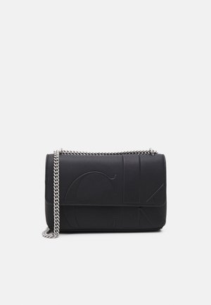 Sac à bandoulière en cuir noir avec grandes initiales en relief et une chaîne argentée, photographié sur un fond gris uni.