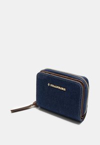 Portafoglio in tessuto blu navy con chiusura a zip, caratterizzato da un logo dorato, dettagli marroni e una superficie texturizzata. Forma compatta e rettangolare.
