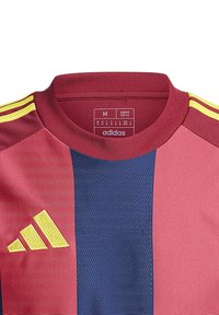 Adidas Sporttrikot in kastanienbraun, blau und gelb. Verfügt über einen Rundhalsausschnitt und ein vertikales Streifendesign. Slim-Fit-Schnitt, strapazierfähiger Stoff.