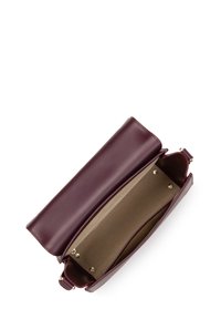 Borsa in pelle bordeaux aperta che mostra un interno beige con un grande scomparto principale e una piccola tracolla con hardware dorato.