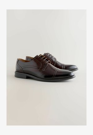 Rudi odiniai bateliai su apvalia nosimi, penkiomis skylių užveržimo raišteliais, siuvimo detalėmis ir juodu guminiu padu.