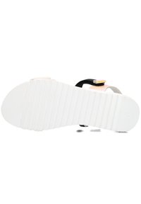 Gummisandalen-Sohle mit einer strukturierten weißen Unterseite, ausgestattet mit einem mehrfarbigen Obermaterial und einem schwarzen Riemen mit einem gelben Akzent.