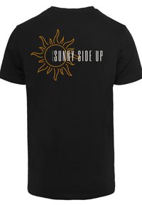 Black cotton t-shirt featuring a sun graphic and the text "KEEP YOUR SUNNY SIDE UP" in white and orange on the back.