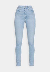 Jeans ajustados de talle alto en denim de color azul claro. Presenta cinco bolsillos, un cierre frontal con bot�ón y un acabado suave y texturizado.