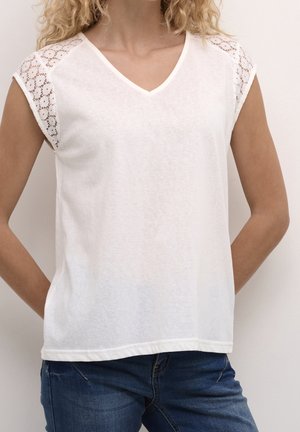 Weißes Kurzarmoberteil mit V-Ausschnitt und Spitzenakzenten auf den Schultern. Weicher, leichter Stoff mit lockerem Schnitt.