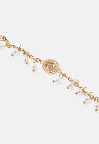 Braccialetto in catena d'oro con piccole perle bianche e dettagli decorativi. Include un gancio circolare con un design a fiore e pietre trasparenti.