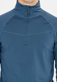 Giacca blu con zip realizzata in tessuto liscio, dotata di un collo alto e cuciture sottili sul petto, che offre una silhouette aderente.