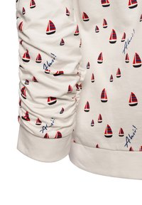 White sweatshirt featuring a repeated pattern of small red and blue sailboats, with gathered sleeves and "Ahoi!" text in blue.