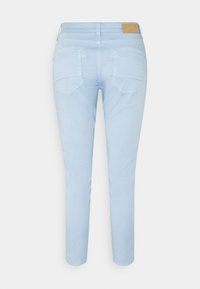 Svetle modré, slim-fit kalhoty s středním pasem, vybavené dvěma zadními kapsami a kontrastním šitím. Vyrobeny z měkké, odolné tkaniny.