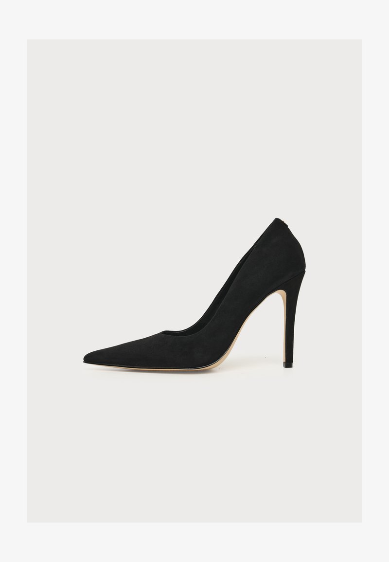 Escarpin noir à bout pointu et talon aiguille fin, photographié de côté sur fond blanc.