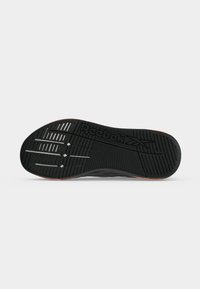 Μαύρη λαστιχένια σόλα παπουτσιού Reebok με υφή και ανάγλυφο το λογότυπο της Reebok στη μέση.