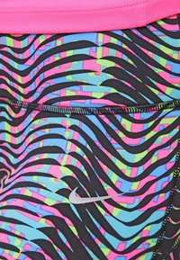 Legginsy sportowe Nike w czarno-niebiesko-różowo-zielonym geometrycznym wzorze. Posiadają różową talię i srebrne logo z boku.