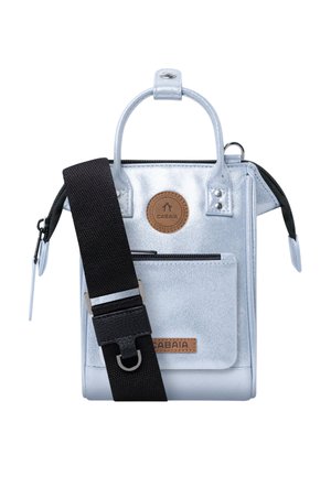 Small metallic silver handbag with front zip pocket, black wide adjustable shoulder strap, and round brown logo patch and label.