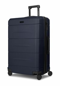 Maleta rígida de color azul marino con superficie texturizada, doble cremallera, asa retráctil y cuatro ruedas giratorias negras para una fácil maniobrabilidad.