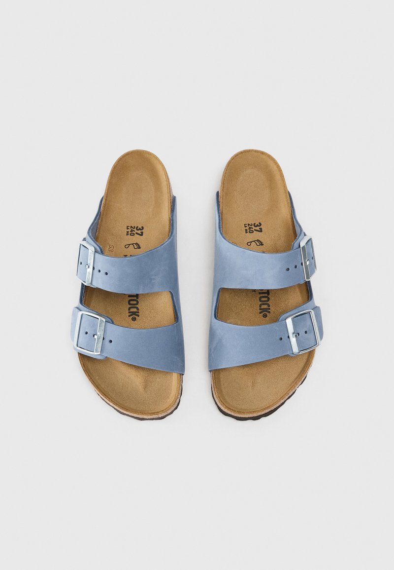 Blaue Ledersandalen mit zwei verstellbaren Schnallen, konturiertem Korkfußbett und einer strukturierten Gummisohle. Minimalistisches Design und praktische Konstruktion.