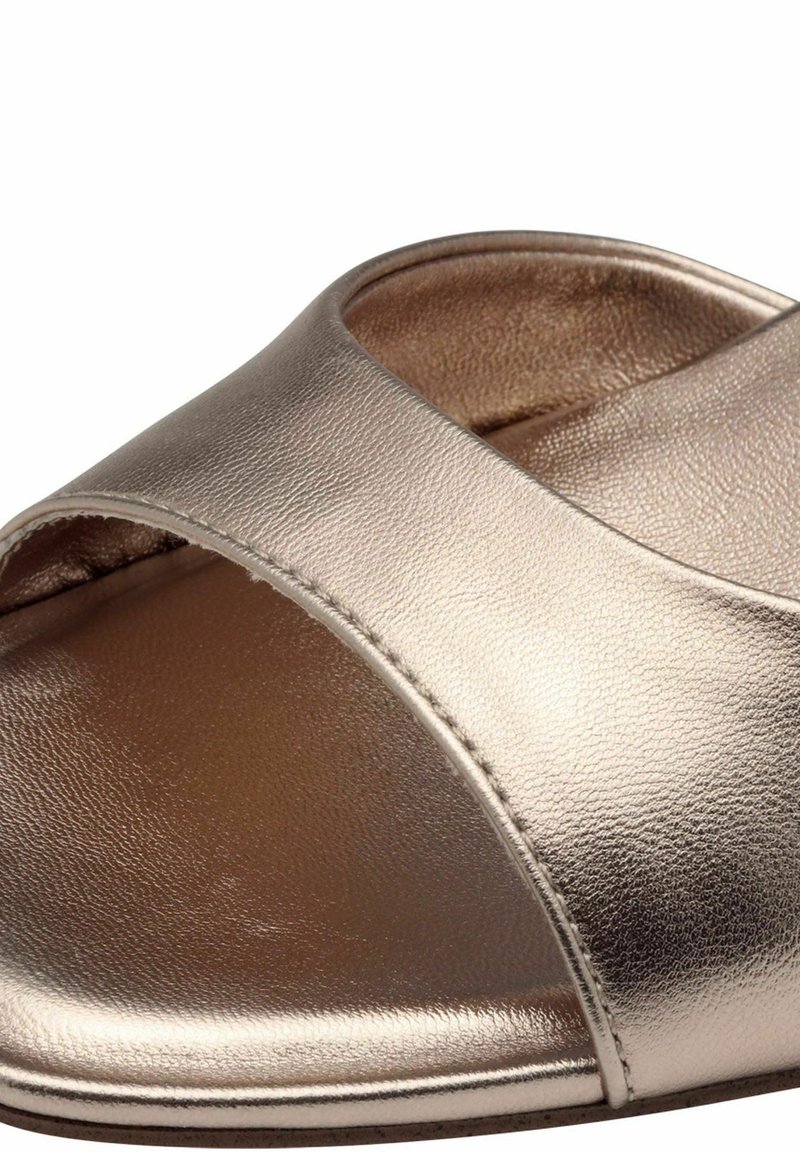 Chausson ouvert en métal doré, avec un large design de brides croisées, une texture lisse et une semelle intérieure rembourrée pour le confort.